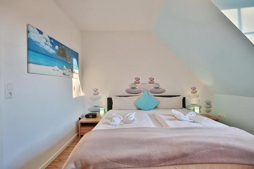 a bedroom with a large bed with white sheets at Ferienhaus Wohldkamp Ferienhaus Wohldkamp in Timmendorfer Strand
