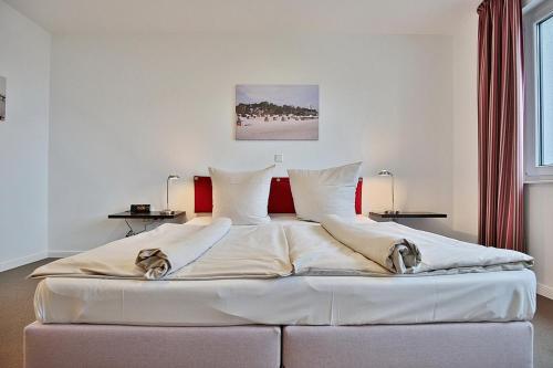 Cette chambre comprend un grand lit blanc et une fenêtre. dans l'établissement Villa Mér Baltique Villa Mér Baltique Appartement 13, à Timmendorfer Strand
