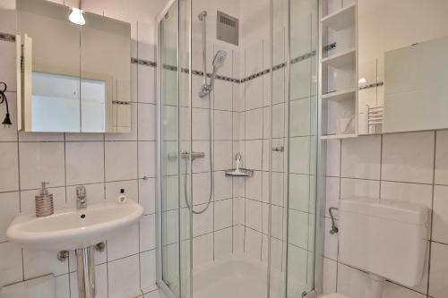 ein Bad mit einer Dusche, einem Waschbecken und einem WC in der Unterkunft Haus Sommerbrise Haus Sommerbrise Appartement 4 in Timmendorfer Strand