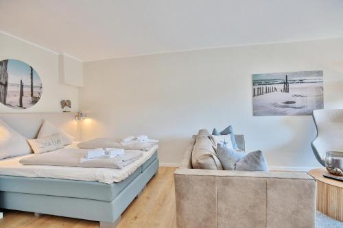 sala de estar con 2 camas y sofá en Villa Idyll Strandstudio Appartement 12 in der Villa Idyll, en Timmendorfer Strand