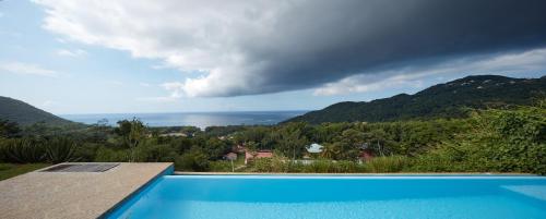 a swimming pool with a view of the ocean at Savane Paille in Deshaies