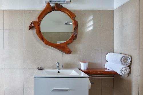 a bathroom with a sink and a mirror on the wall at Savane Paille in Deshaies