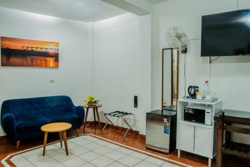ein Wohnzimmer mit einem blauen Sofa und einem TV in der Unterkunft Hospedaje Gran Imperial in Tumbes