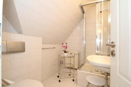 ein weißes Bad mit einem Waschbecken und einem WC in der Unterkunft Am Rosenhain 8 Am Rosenhain 8 Appartement 4 in Timmendorfer Strand