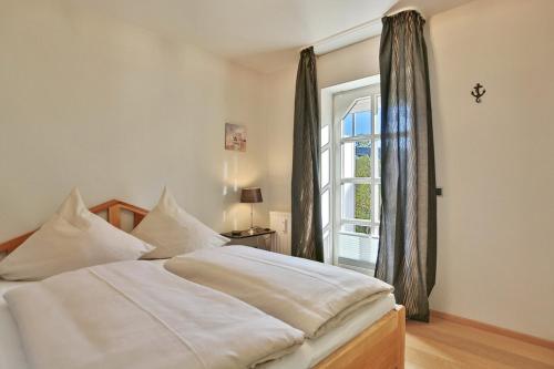 een slaapkamer met een bed en een raam bij Am Rosenhain 12 Am Rosenhain 12 Appartement 1 in Timmendorfer Strand