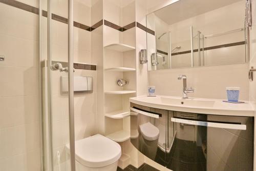 La salle de bains blanche est pourvue de toilettes et d'un lavabo. dans l'établissement Am Rosenhain 12 Am Rosenhain 12 Appartement 1, à Timmendorfer Strand