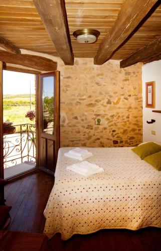 a bedroom with a bed and a door to a balcony at Casa Rural Las Águedas in Murias de Rechivaldo
