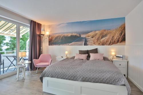 1 dormitorio con 1 cama y una pintura en la pared en Strandhotel Scharbeutz Sweet little Beachside, en Scharbeutz