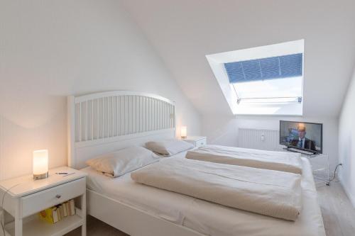 - une chambre blanche avec un grand lit et une fenêtre dans l'établissement Residenz Ostseestrand Residenz Ostseestrand Appartement 30, à Scharbeutz