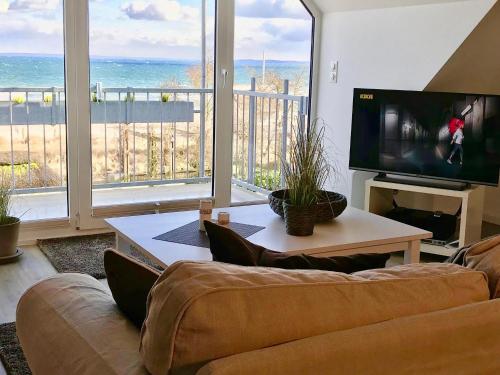 a living room with a couch and a large window at Strandduene Stranddüne Appartement 12 in Haffkrug