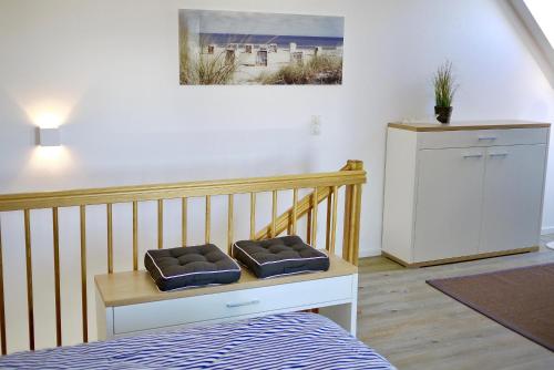 a room with a bed and a table with two pillows at Strandduene Stranddüne Appartement 12 in Haffkrug