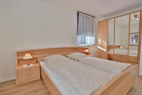 um quarto com uma cama grande e um espelho em Barke Barke Appartement 307 em Scharbeutz