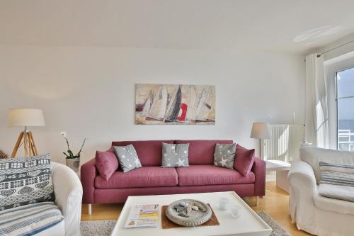 a living room with a red couch and a table at Stranddomizil Stranddomizil Appartement 13 in Haffkrug