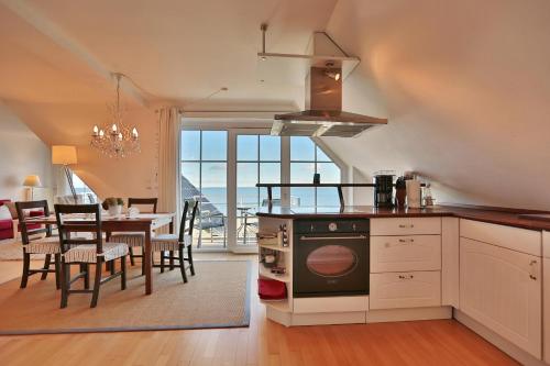 a kitchen and dining room with a table and a stove at Stranddomizil Stranddomizil Appartement 13 in Haffkrug