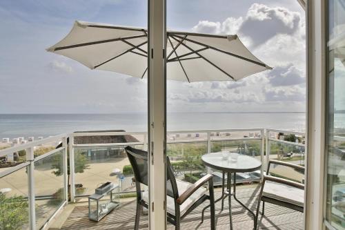 a balcony with a table and an umbrella at Stranddomizil Stranddomizil Appartement 13 in Haffkrug