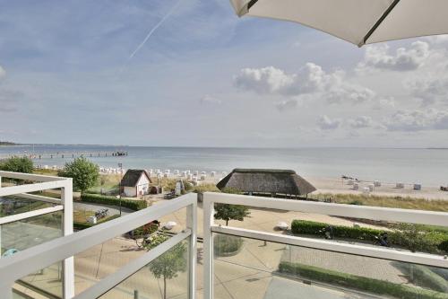 a balcony with a view of the beach and the ocean at Stranddomizil Stranddomizil Appartement 13 in Haffkrug
