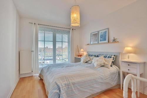 a bedroom with a bed and a large window at Stranddomizil Stranddomizil Appartement 13 in Haffkrug