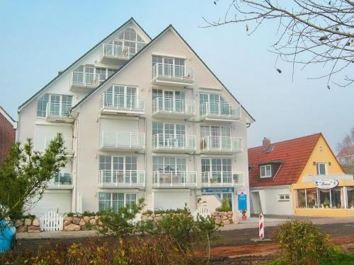 a large white building with balconies on the side of it at Stranddomizil Stranddomizil Appartement 13 in Haffkrug