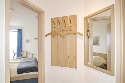 沙博伊茨Residenz Ostseestrand Appartement 16的带镜子的房间和一间带床的卧室