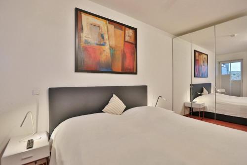 ein Schlafzimmer mit einem großen weißen Bett und einem Spiegel in der Unterkunft Residenz Ostseestrand Residenz Ostseestrand Appartement 10 in Scharbeutz