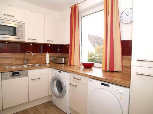 eine Küche mit einer Waschmaschine und einem Fenster in der Unterkunft Ferienhaus LUV & LEE Ferienhaus LUV und LEE in Scharbeutz