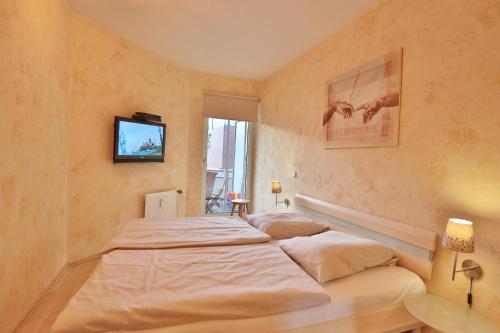 沙博伊茨Residenz Ostseestrand Appartement 2的一间卧室，有两张床和一台挂在墙上的电视