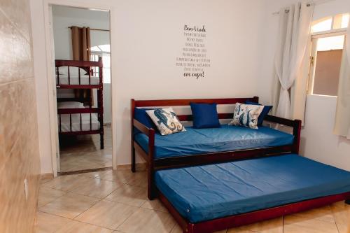 um quarto com uma cama com lençóis azuis e um espelho em Moni & Junior Hospedagem em Angra dos Reis