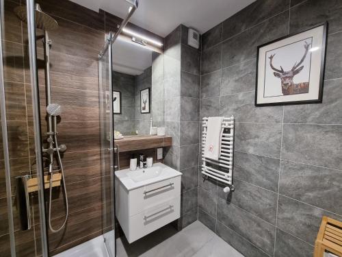 La salle de bains est pourvue de toilettes, d'un lavabo et d'une douche. dans l'établissement Apartament 10 Resort Kozubnik Kiczora SPA - 5D Apartments, à Porąbka