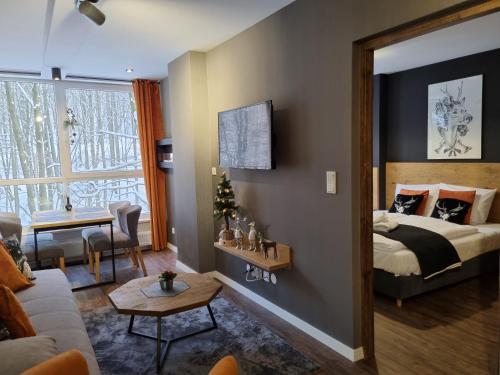 - une chambre avec un lit et un salon dans l'établissement Apartament 10 Resort Kozubnik Kiczora SPA - 5D Apartments, à Porąbka