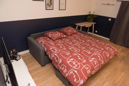 una camera con un letto con una coperta rossa e bianca di Le Photographe Cosy Douai centre a Douai