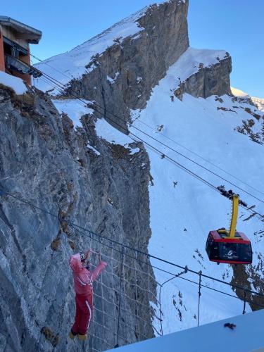 a person standing on a ski lift on a mountain at Hotel Regina Terme in Leukerbad