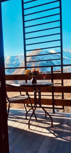 a table with a glass of wine on a balcony at Marshal Gudauri in Gudauri