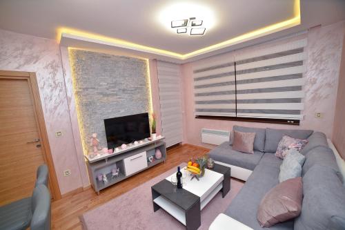 a living room with a couch and a tv at Sunset Lux S3 Wellness & Spa Zlatibor in Zlatibor