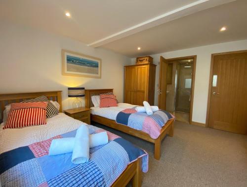 1 dormitorio con 2 camas y almohadas azules y rojas en Ohana House en Newquay