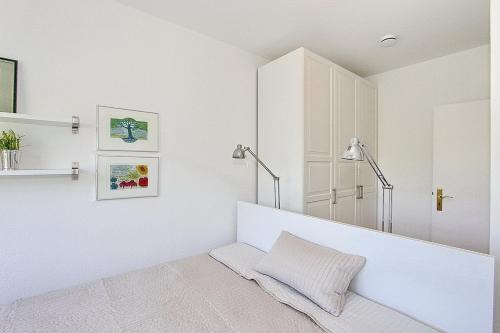 ein weißes Zimmer mit einer Bank und einem Spiegel in der Unterkunft Domizil Strandallee 30 Domizil Strandallee 30 Appartement 32 in Timmendorfer Strand