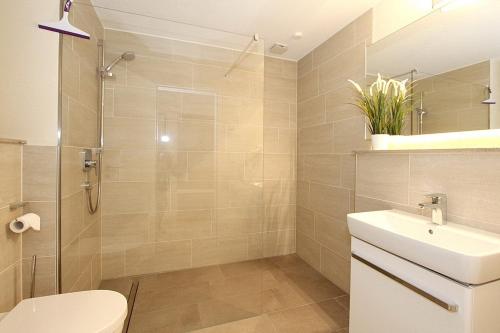 uma casa de banho com um chuveiro, um WC e um lavatório. em Villa Stern Villa Stern Appartement 06 em Timmendorfer Strand