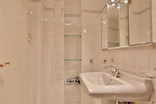 ein weißes Badezimmer mit einem Waschbecken und einem Spiegel in der Unterkunft Haus Parkblick, Timmendorfer Strand Haus Parkblick Appartement 07 in Timmendorfer Strand