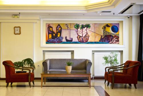 a living room with a couch and two chairs at Vergina Hotel in Thessaloniki