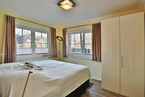 una camera con un letto e due finestre di Baltic Sea Baltic Sea Appartement 1 a Niendorf