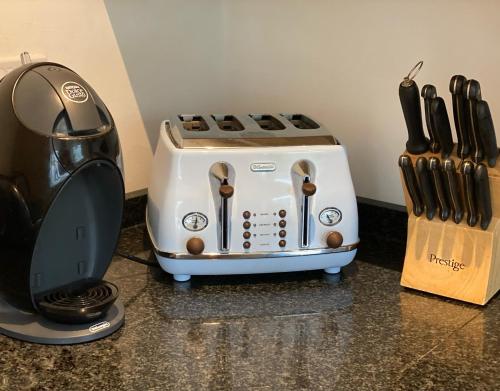 a toaster sitting on top of a counter with knives at OHANA HOUSE - Unbeatable Location - UK's Best Beaches in Newquay