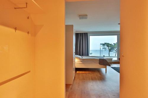 een kamer met een slaapkamer met een bed en een raam bij Haus Seebrücke Haus Seebrücke Appartement 03 in Niendorf