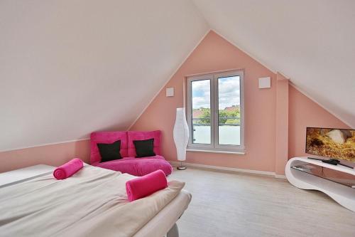 ein Schlafzimmer mit einem großen Bett mit einem rosa Stuhl in der Unterkunft Haus Bergstrasse 4 Haus Bergstraße 4 Appartement 9 in Timmendorfer Strand