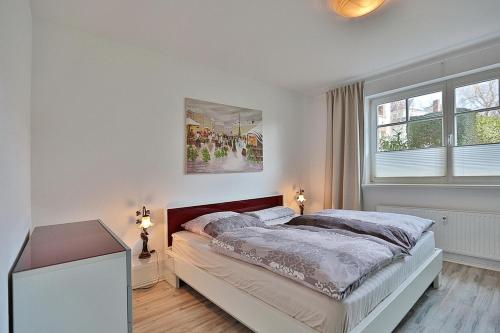 - une chambre blanche avec un lit et 2 fenêtres dans l'établissement Haus Strandstrasse Strandstrasse 150 Appartement 2, à Niendorf
