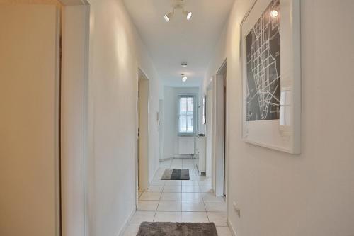 pasillo con paredes blancas y suelo de baldosa en Haus Ostseeallee Ostseeallee Appartement 56 en Niendorf