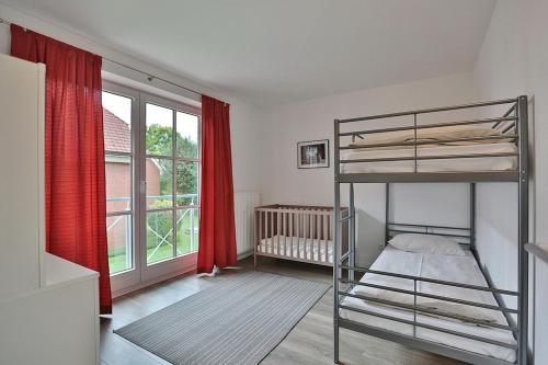 ein Schlafzimmer mit einem Etagenbett und einem Kinderbett in der Unterkunft Haus Ostseeallee Ostseeallee Appartement 56 in Niendorf
