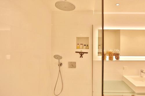 eine Dusche mit Glastür neben einem Waschbecken in der Unterkunft Haus Wolburgstraße 1 Haus Wolburgstraße 1a Penthouse Haifisch Appartement 5 in Timmendorfer Strand