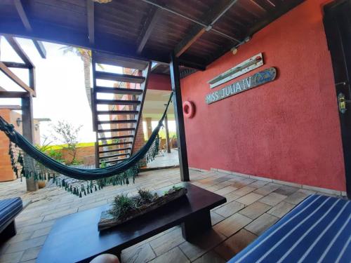 a room with a hammock and a red wall at Pousada Icthus in Cabo Frio