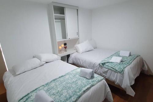 Cette chambre comprend 2 lits et un miroir. dans l'établissement Diego&Sergio3 Apartment Rivero Jacuzzi Piso3, à Huaraz