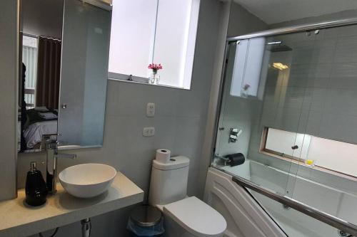 y baño con aseo, lavabo y espejo. en Diego&Sergio3 Apartment Rivero Jacuzzi Piso3, en Huaraz