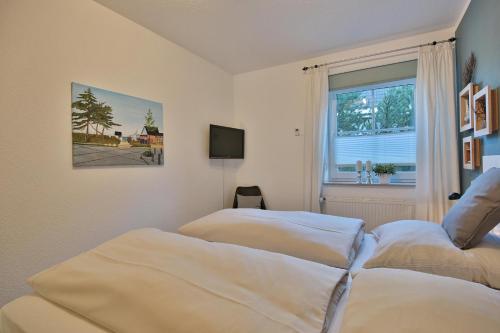 ein Schlafzimmer mit zwei Betten und einem Fenster in der Unterkunft Residenz Alte Bergstraße Residenz Alte Bergstrasse Appartement 5 in Scharbeutz